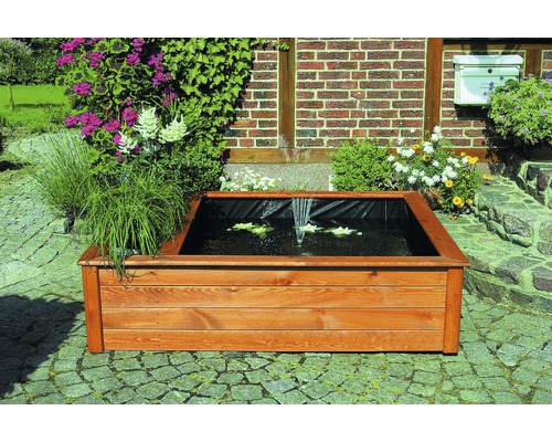 Holzteich mit Seerosen und Springbrunnen im Garten