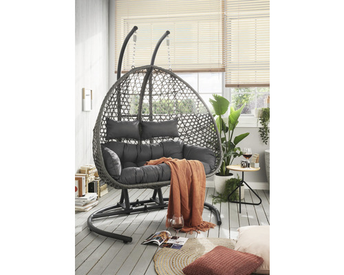 Hängesessel mit Stahlgestell, Rattanoptik und Polsterkissen im Wohnzimmer