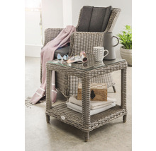 Scène de jardin avec fauteuil en rotin et table d''appoint avec plateau en verre