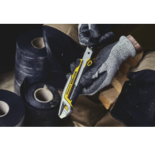 Stanley Fatmax Cuttermesser in der Hand mit Arbeitshandschuhen