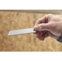 Hand hält Klinge für Cuttermesser