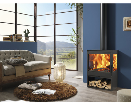 Wohnzimmer mit Kaminofen, Sofa und großem Fenster mit Ausblick