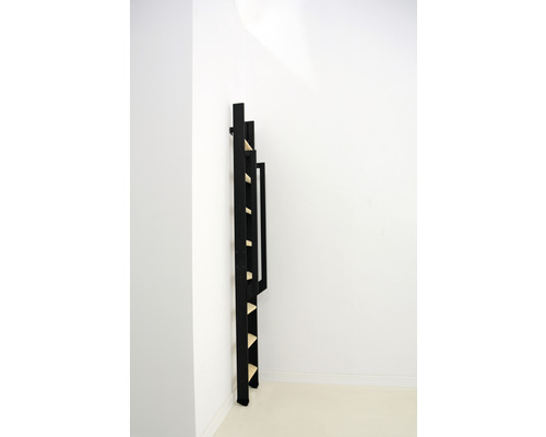 Étagère échelle en bois noire contre un mur blanc