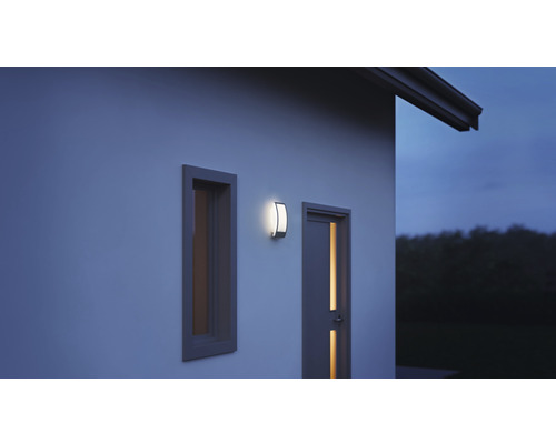 Applique murale extérieure à côté d''une fenêtre et d''une porte sur un mur de maison