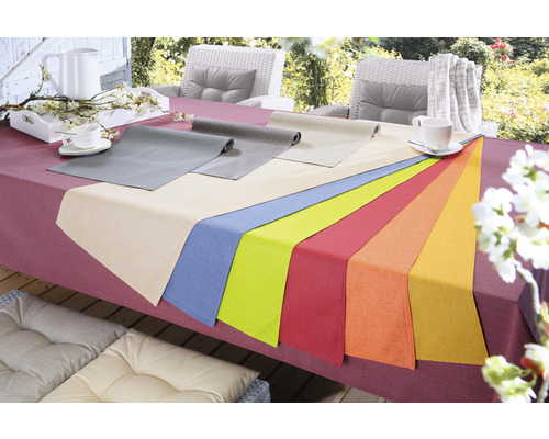 Tischdekoration mit Tischläufern in verschiedenen Farben auf einem Gartentisch