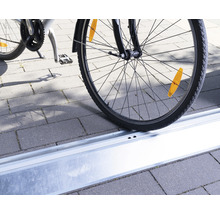 Pneu de vélo dans un rail de stationnement pour vélos sur des pavés