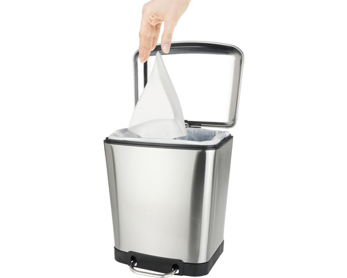 Edelstahl-Treteimer mit Hand, die einen Müllbeutel einlegt
