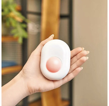 Weißer Handwärmer mit rundem Heizelement in der Hand