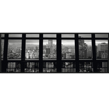 Photographie en noir et blanc avec vue à travers une fenêtre sur une ville