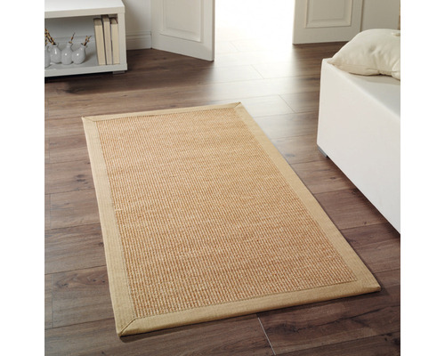 Rechteckiger Teppich aus Naturfasern auf Holzboden in einem Wohnraum.