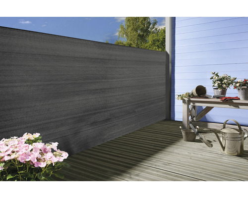Gartenszene mit Sichtschutzzaun und Gartenzubehör auf einer Terrasse