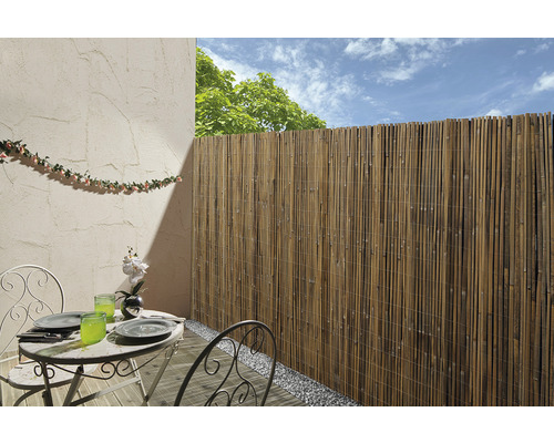 Sichtschutzwand aus Bambus auf einem Balkon mit Gartentisch und Dekoration
