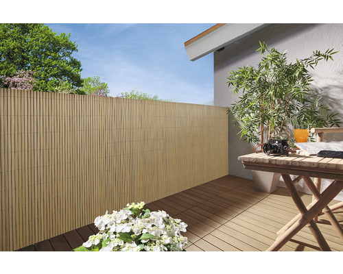 Terrasse avec brise-vue en bambou, plancher en bois et table en bois