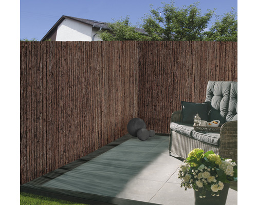 Scène de terrasse avec clôture de protection visuelle en matériaux naturels et coin salon