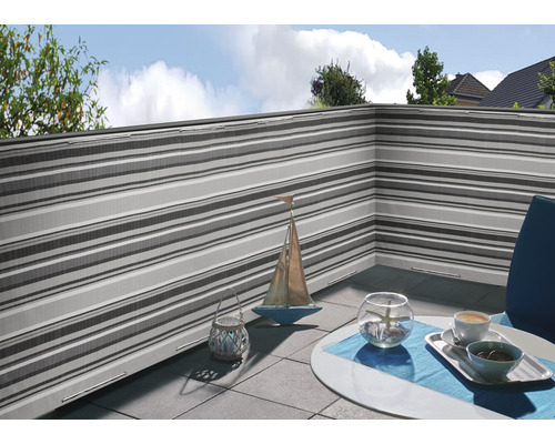 Balcon avec pare-vent à rayures et table décorée