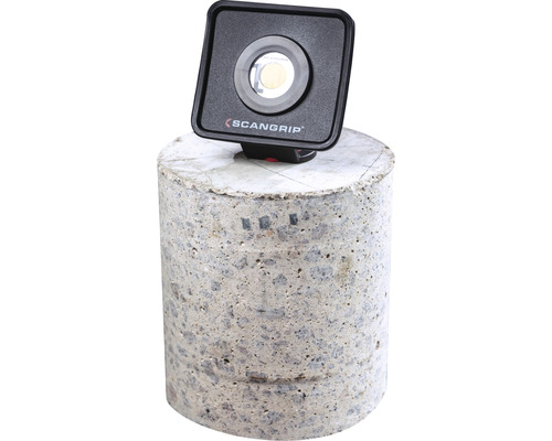 Logo Scangrip. Lampe de travail carrée sur béton.