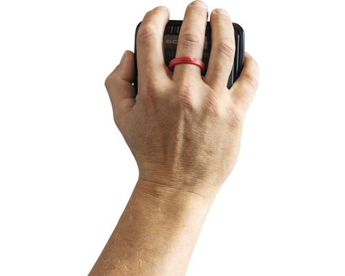 Une main portant une bague rouge tient un smartphone.