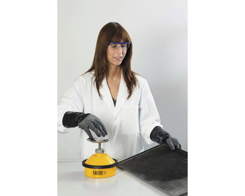 Eine Frau mit Schutzbrille und Schutzhandschuhen reinigt ein Gerät mit einem Tuch