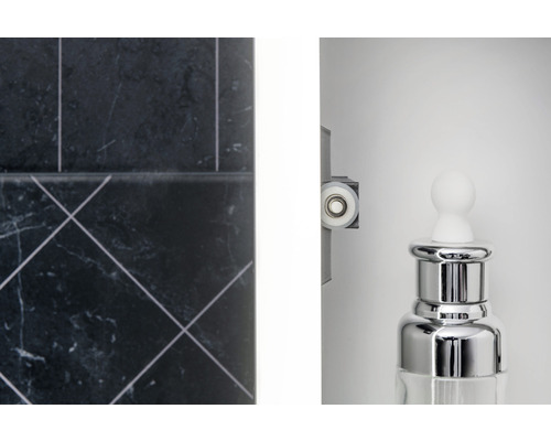 Detailaufnahme eines Badezimmers mit Fliesen, Duschkabinenrolle und einem Spender