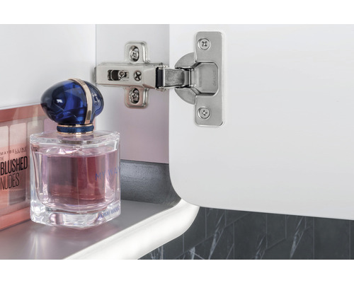 Charnière sur une armoire blanche avec des produits cosmétiques