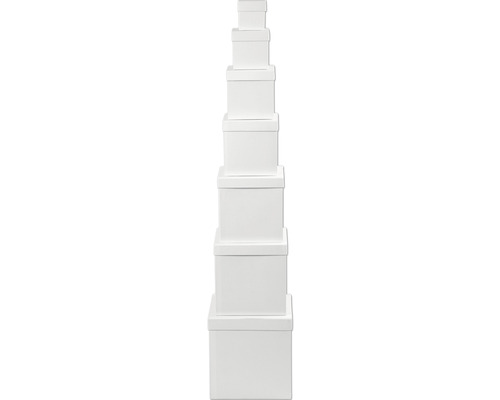 Pile de sept boîtes de rangement blanches en carton avec couvercle.