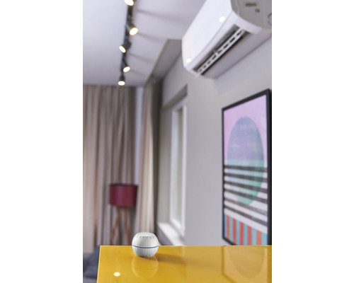 Scène d''un intérieur avec climatisation et un appareil blanc rond sur une table.