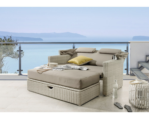 Lit de jour double en rotin avec coussins et vue sur la mer sur une terrasse