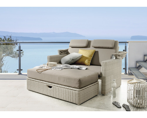 Salon de jardin avec surface en rotin, coussin et coussins sur une terrasse avec vue sur la mer