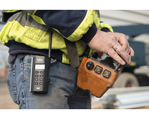 Gros plan d''un homme avec une radio et une commande de grue