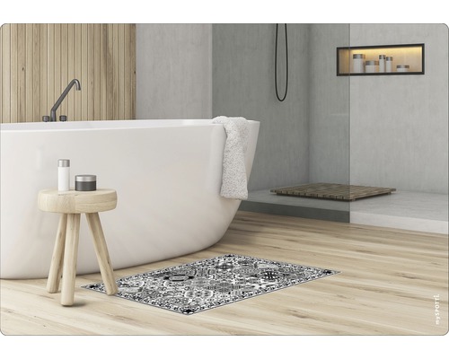 Badezimmer mit Badewanne, Hocker und gemusterter Badematte