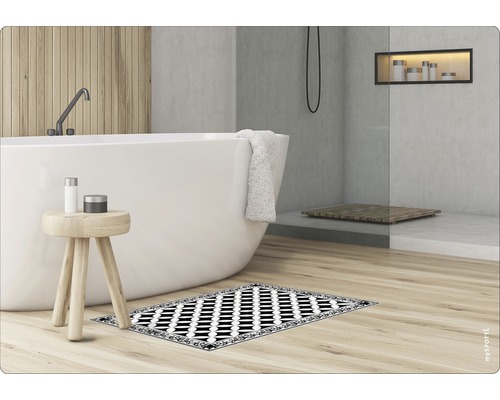 Badezimmer mit Badewanne, Hocker und gemusterter Badematte
