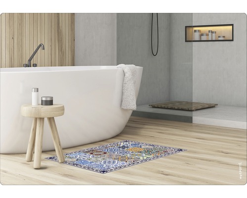Badezimmer mit Badewanne, Hocker und einem gemusterten Badvorleger