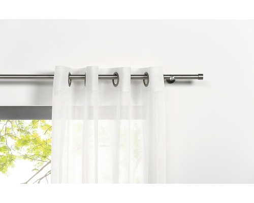 Gardinenstange mit weißem Vorhang am Fenster.