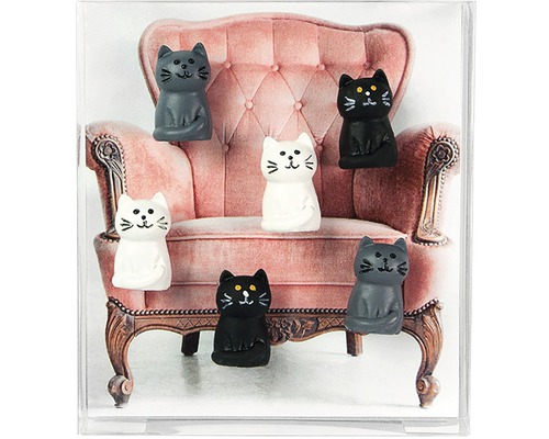 Dekoration mit Katzenfiguren vor einem Sessel