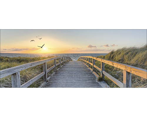 Holzsteg führt zum Strand bei Sonnenuntergang