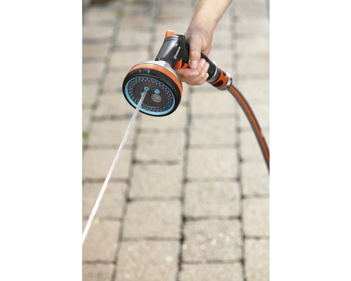 Gartenschlauch mit Sprühkopf in der Hand
