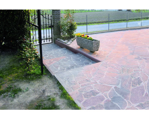 Außenbereich mit Natursteinpflaster und einem Blumenkasten aus Stein