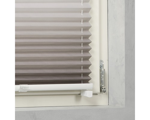 Vue détaillée d''un store plissé gris sur la fenêtre