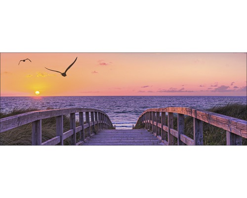 Pont menant à la mer au coucher du soleil avec des oiseaux en vol