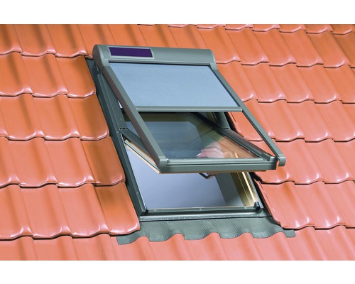 Fenêtre de toit ouverte avec volet roulant sur un toit en tuiles