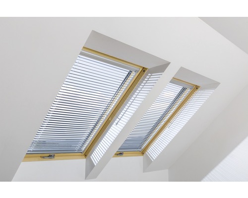 Zwei Dachfenster mit Jalousien in einem hellen Raum.