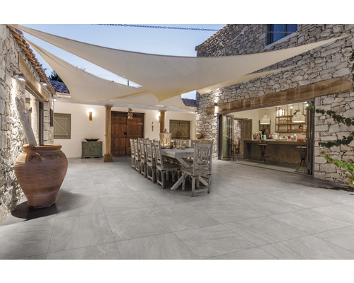 Dalle de terrasse en grès cérame fin Alpen bord rectifié 120 x 60 x 2 cm Espace extérieur avec sol carrelé, longue table, chaises et voile d''ombrage