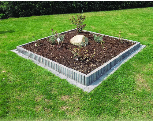 Quadratisches Blumenbeet mit Pflanzen und Rollbordsteinen im Garten