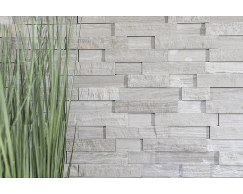 Wandverkleidung aus Stein mit Gras im Vordergrund