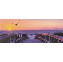 Pont en bois sur la plage avec vue sur la mer et le coucher du soleil