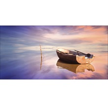 Ein kleines Boot mit Ruder liegt auf dem Wasser vor einem bewölkten Himmel.
