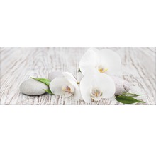 Weiße Orchideenblüten mit Steinen auf Holztisch