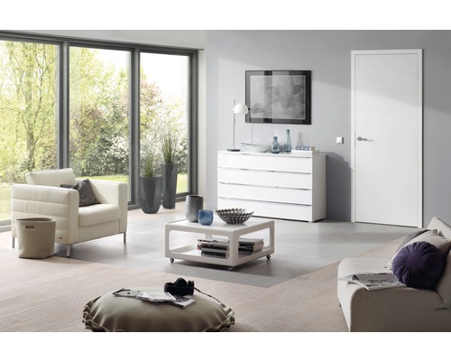 Helles Wohnzimmer mit Sessel, Kommode, Tisch und Tür