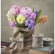 Bouquet dans un sac en papier avec un ruban et des bobines sur des livres
