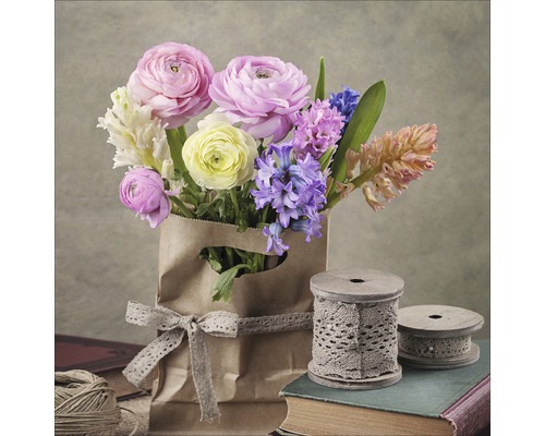 Bouquet dans un sac en papier avec un ruban et des bobines sur des livres